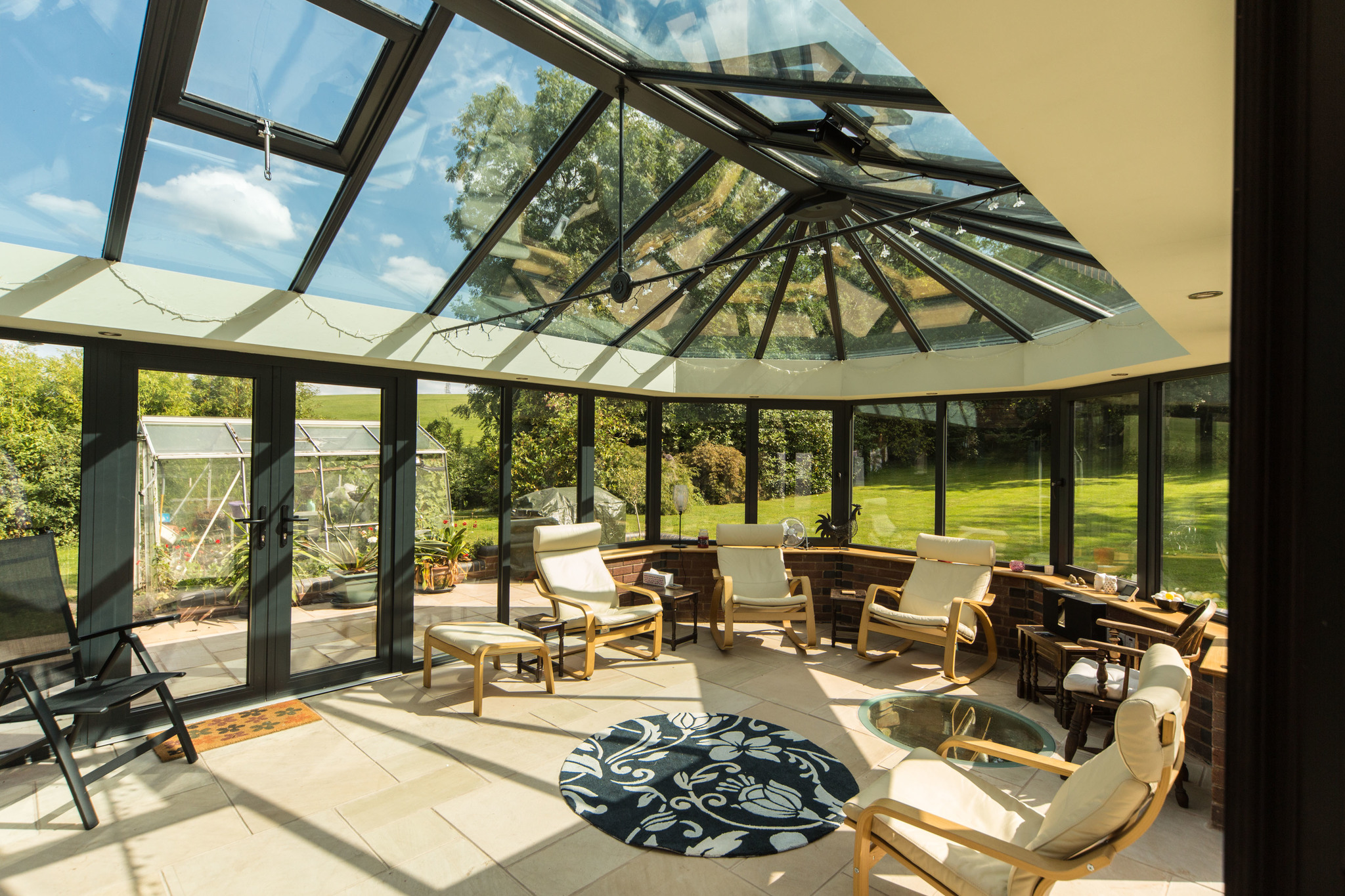 A {large} conservatory with a glass roof offering {stunning views} in Bishop's Cleeve.